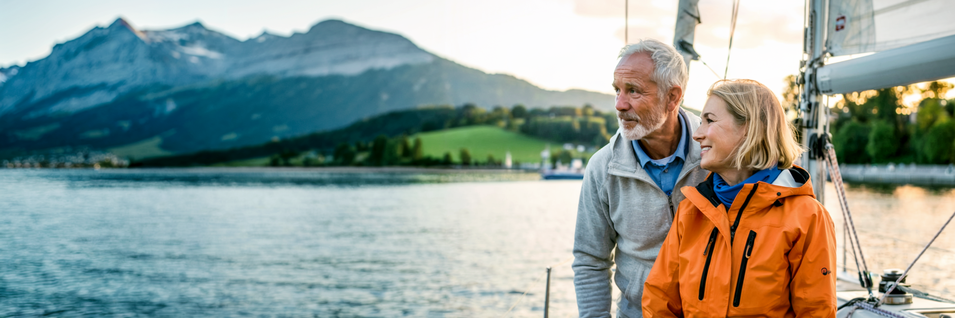 Seniorenpaar segelt auf einem See mit Bergen im Hintergrund. Illustration für Abenteuer und Freiheit im Ruhestand. Konzept für aktive AHV-Rentner bei Ausgleichskasse Migros.