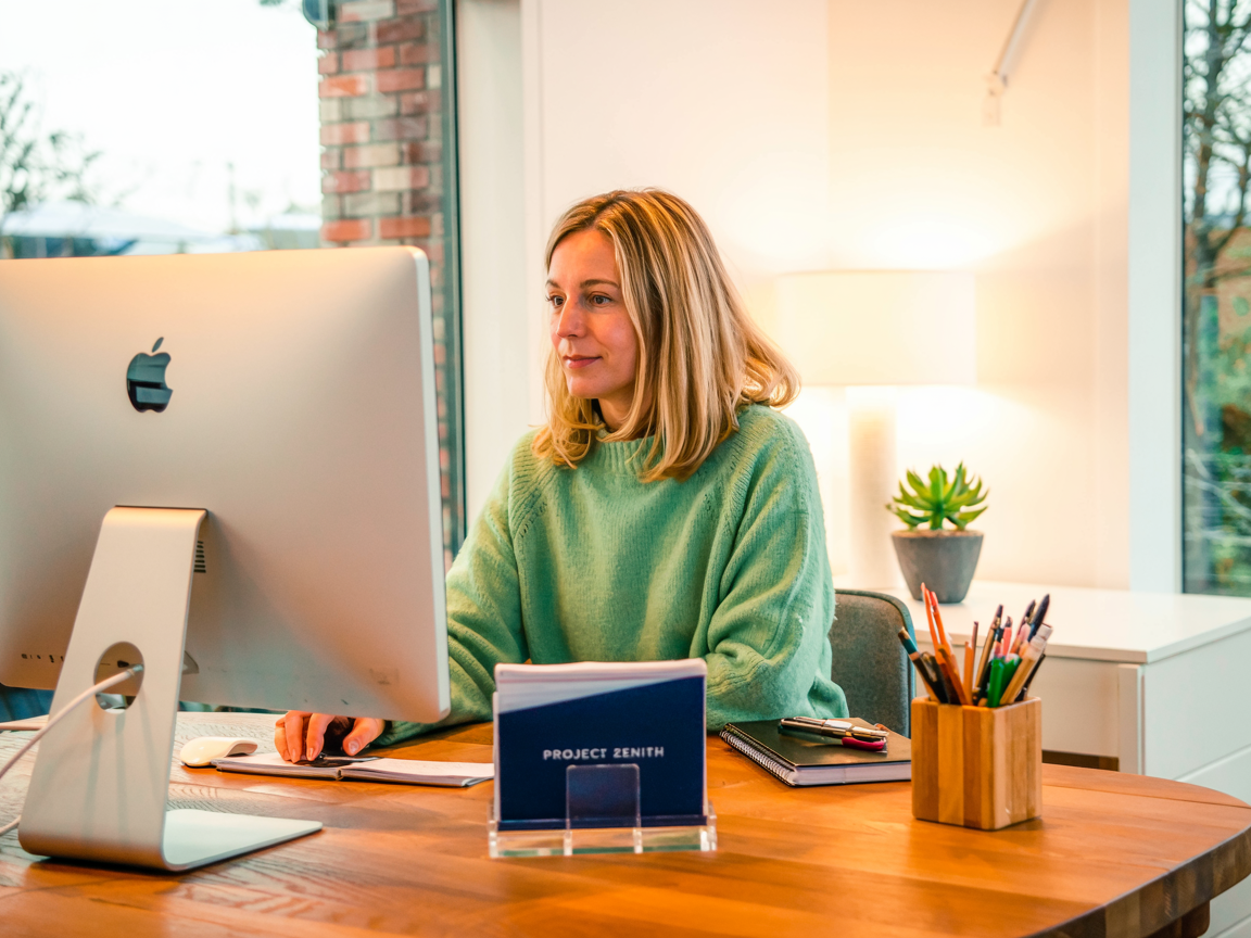Frau arbeitet konzentriert am Computer und symbolisiert digitale Kompetenz im Alter und flexible Erwerbstätigkeit. Illustration für lebenslanges Lernen und Beratung. Konzept für aktive AHV-Rentner bei Ausgleichskasse Migros.
